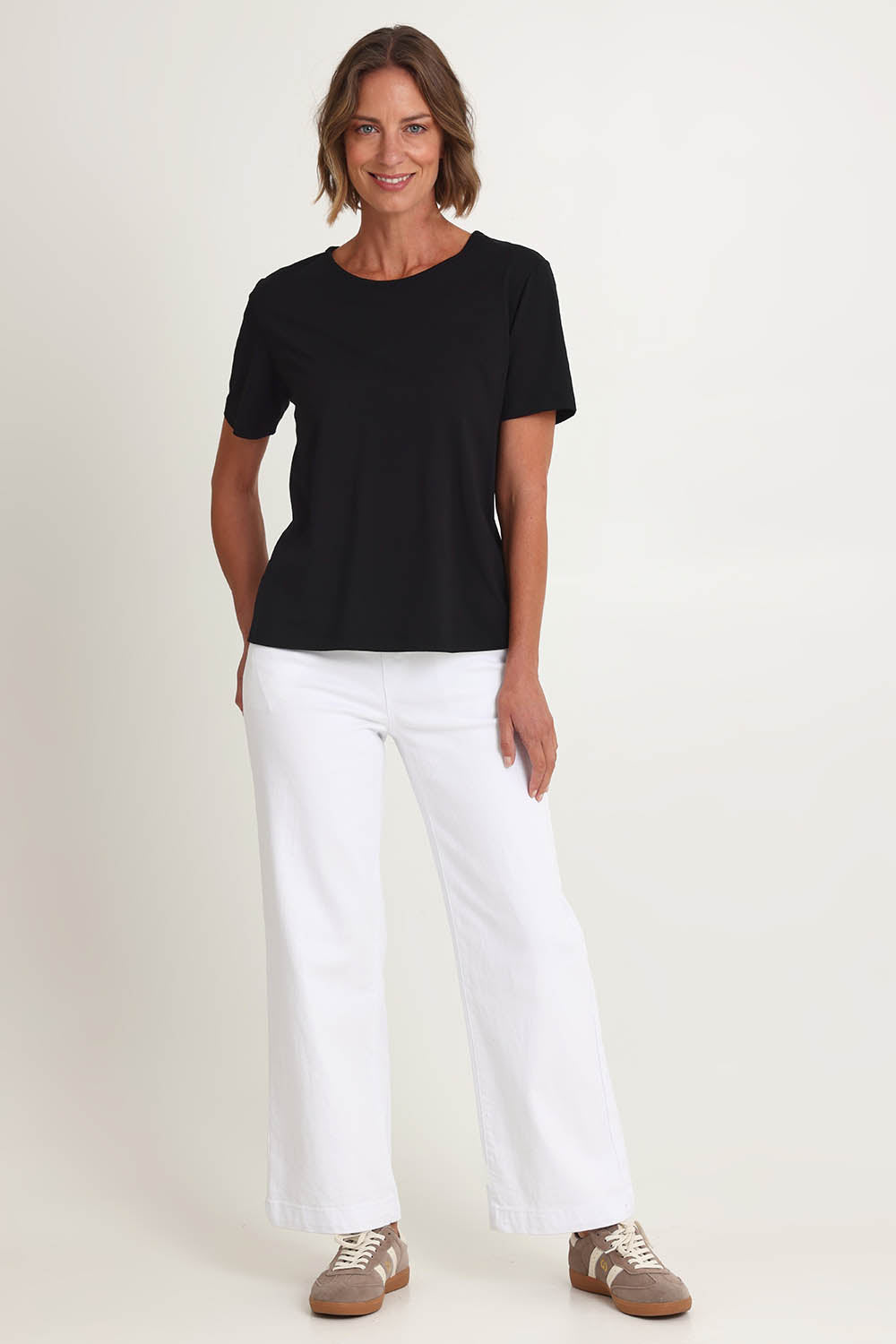 Model Riina wearing size S of the Maddy Wide Leg Jean in colour White (White), from the front, showing the whole outfit