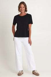 Model Riina wearing size S of the Maddy Wide Leg Jean in colour White (White), from the front, showing the whole outfit