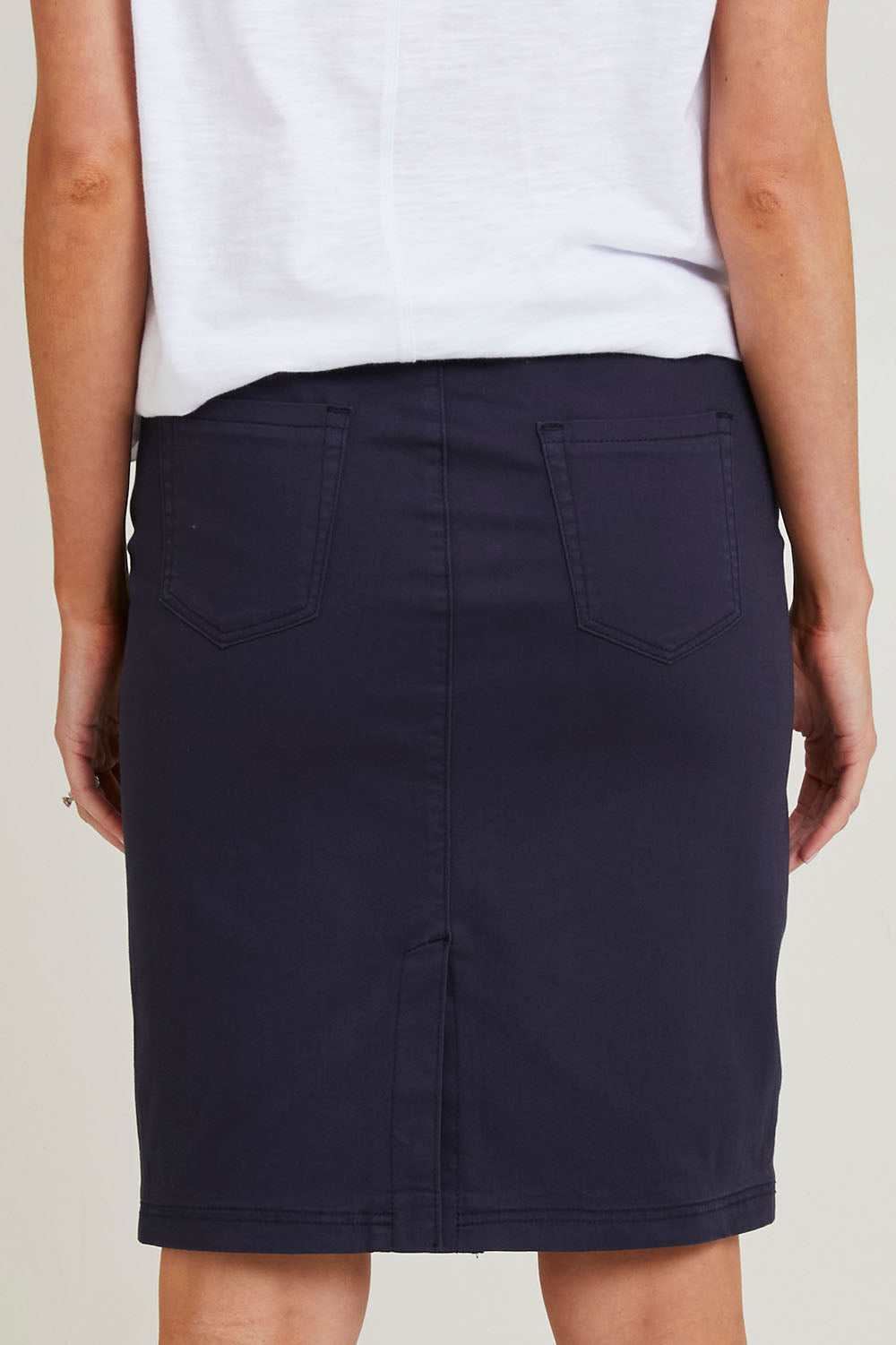 Model Grace wearing size S of the Portia Denim Skirt in colour Navy (Blue), from the back