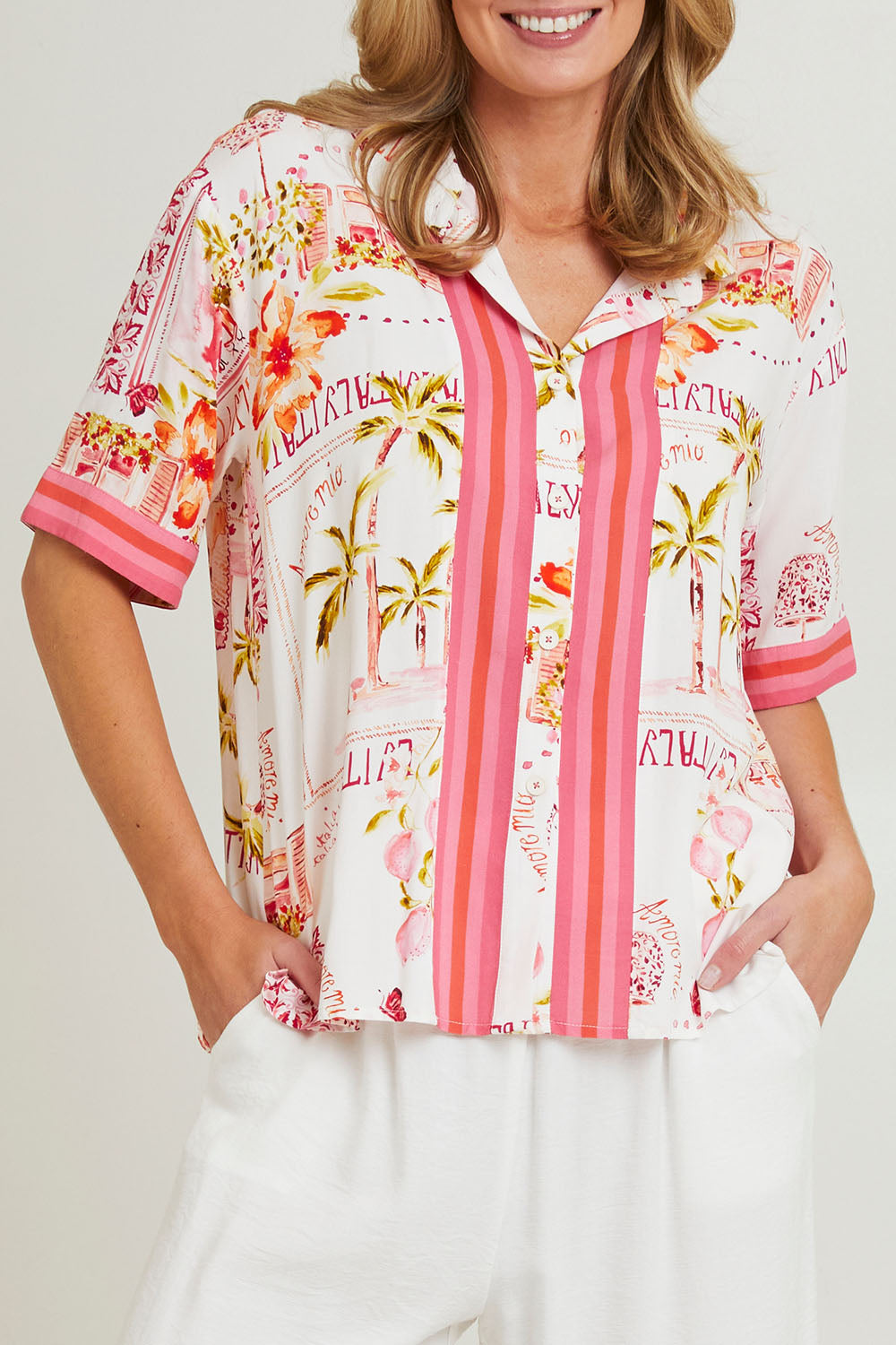 Model Grace wearing size S of the Ciao Bella Shirt in colour Pink (Pink), from the front, cropped image