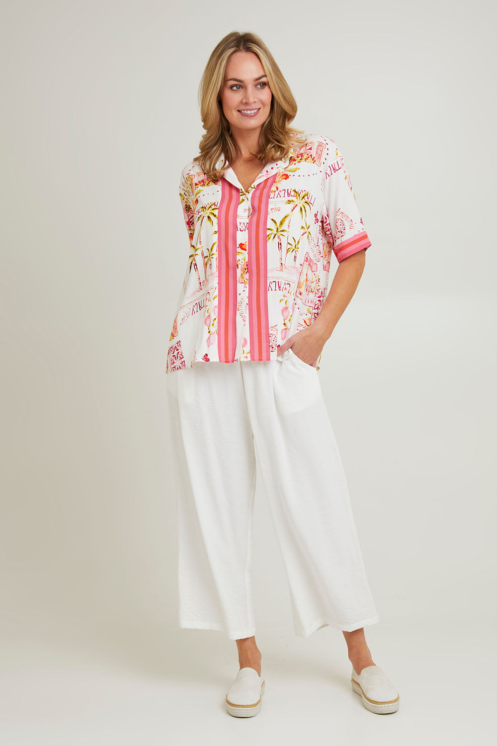 Model Grace wearing size S of the Ciao Bella Shirt in colour Pink (Pink), from the front, showing the whole outfit