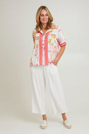 Model Grace wearing size S of the Ciao Bella Shirt in colour Pink (Pink), from the front, showing the whole outfit