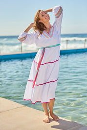 Model Katie wearing size S of the Byron Ciao Cotton Dress in colour White (White), from the front, showing the whole outfit