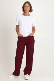 Model Riina wearing size S of the Carpenter Wide Leg Jean in colour Shiraz (Red), from the front, showing the whole outfit