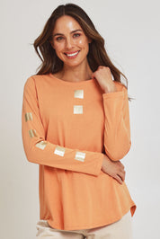 Model Madeline wearing size S of the Be Square Cotton Blend Tee in colour Melon, from the front, cropped image