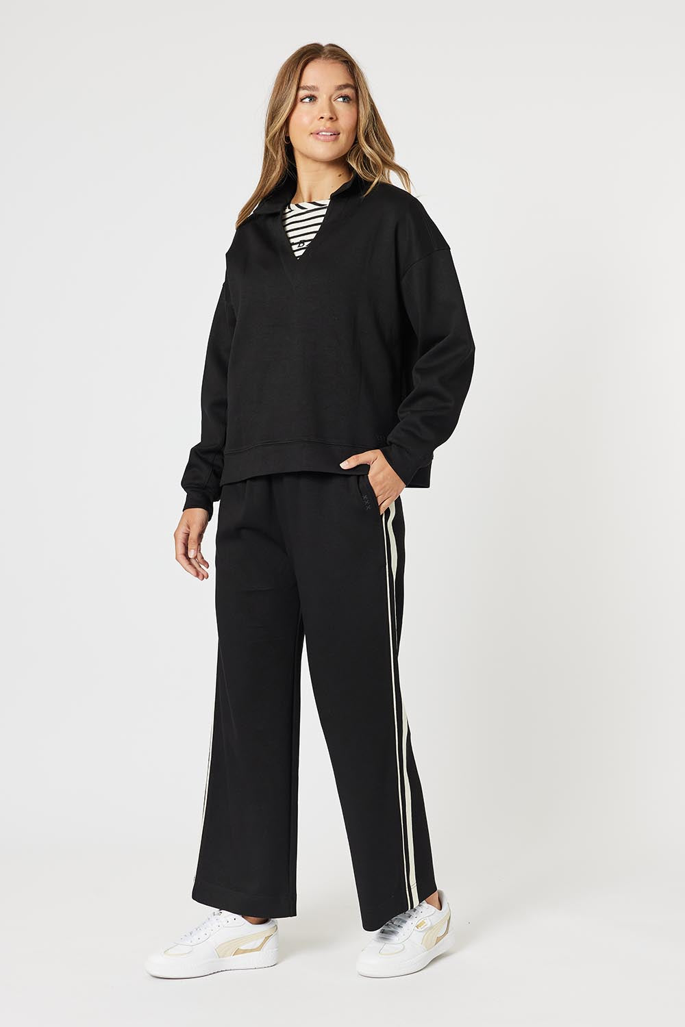 A model wearing the Urban Pant in colour Black (Black), from the front, showing the whole outfit