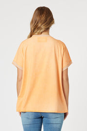 A model wearing The Sienna Linen Blend Tee in colour Orange, from the back