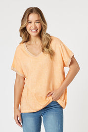 A model wearing The Sienna Linen Blend Tee in colour Orange, from the front, cropped image