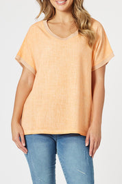 A model wearing The Sienna Linen Blend Tee in colour Orange, from the front, cropped image