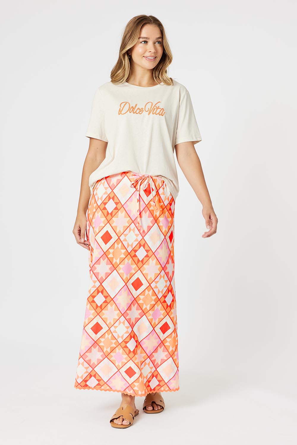A model wearing the Corfu Print Linen Blend Skirt in colour Mango, from the front, showing the whole outfit