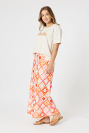 A model wearing the Corfu Print Linen Blend Skirt in colour Mango, from the front, showing the whole outfit