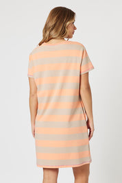 A model wearing the Love & Kisses Cotton Dress in colour Mango, from the back
