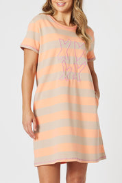 A model wearing the Love & Kisses Cotton Dress in colour Mango, from the front, cropped image
