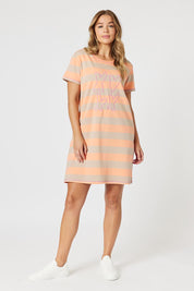 A model wearing the Love & Kisses Cotton Dress in colour Mango, from the front, showing the whole outfit