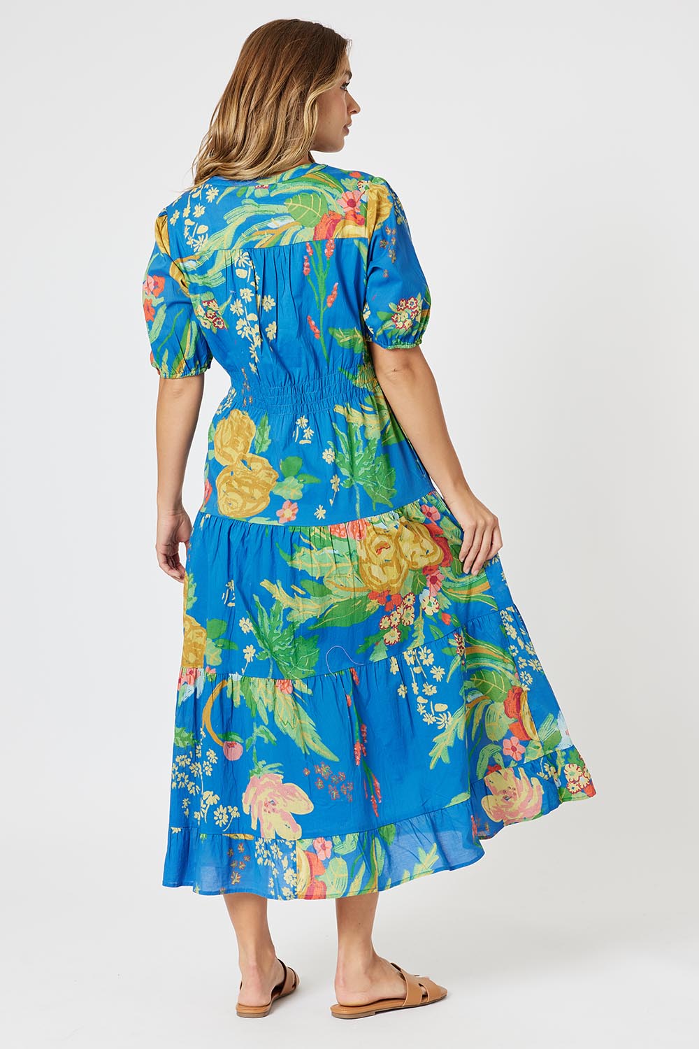 A model wearing the Tropics Cotton Dress in colour Blue (Blue), from the back