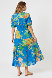 A model wearing the Tropics Cotton Dress in colour Blue (Blue), from the back