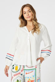 A model wearing the Ric Rac Cotton Tunic in colour Whiteblue (White), from the front, cropped image