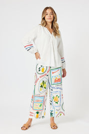 A model wearing the Ric Rac Cotton Tunic in colour Whiteblue (White), from the front, showing the whole outfit