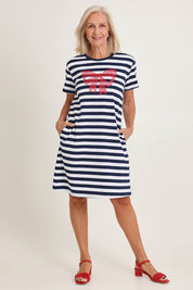 Model Sandy wearing size S of the Red Bow Stripe Cotton Dress in colour Navy (Blue), from the front, showing the whole outfit