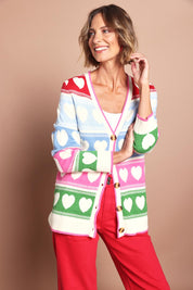 Model Riina wearing size S of the Chic Hearts Cardigan in colour Pink, from the front, cropped image
