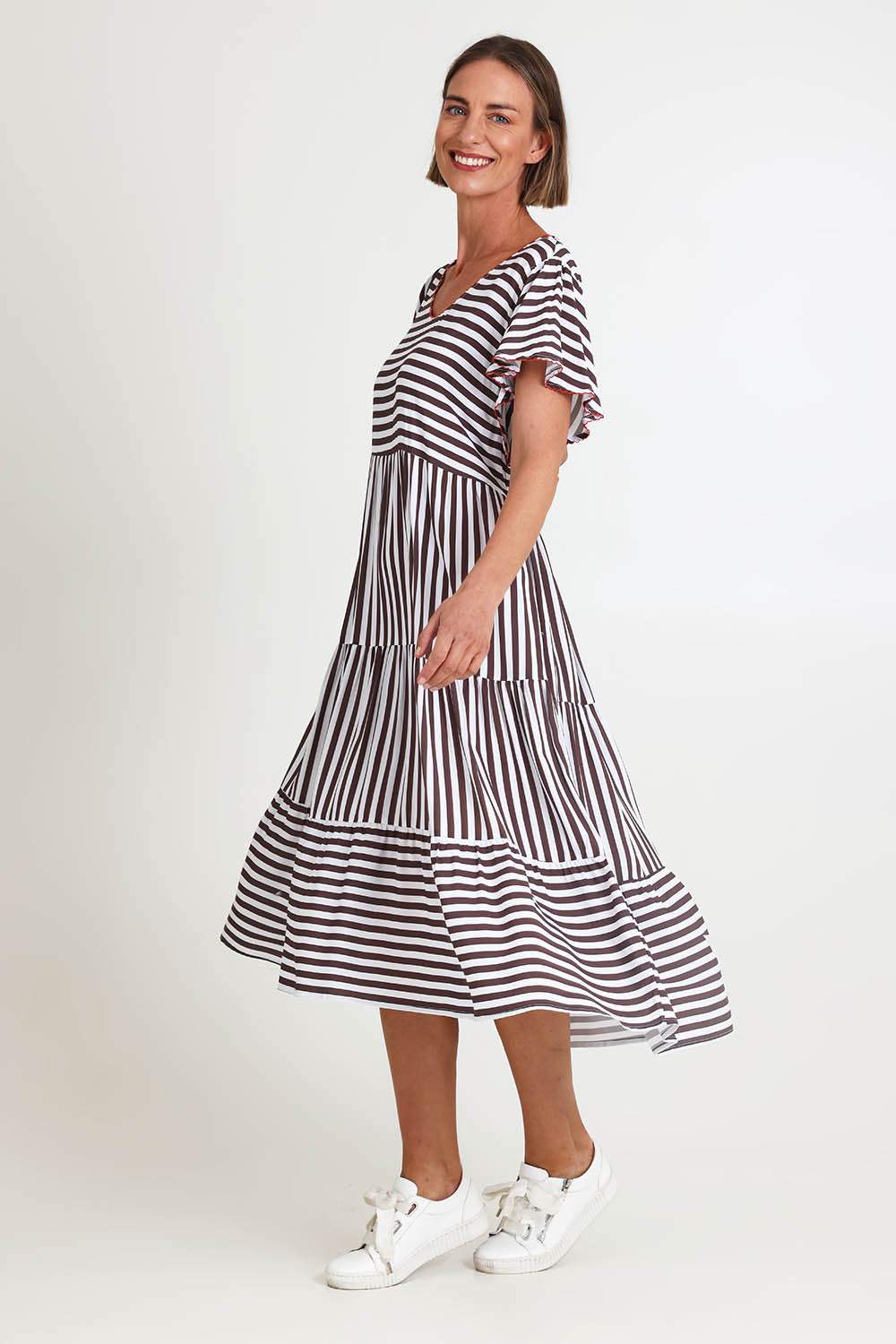 Model Riinar wearing size 10 of the Kalahari Stripe Dress – Coffee in colour Coffee, from the front