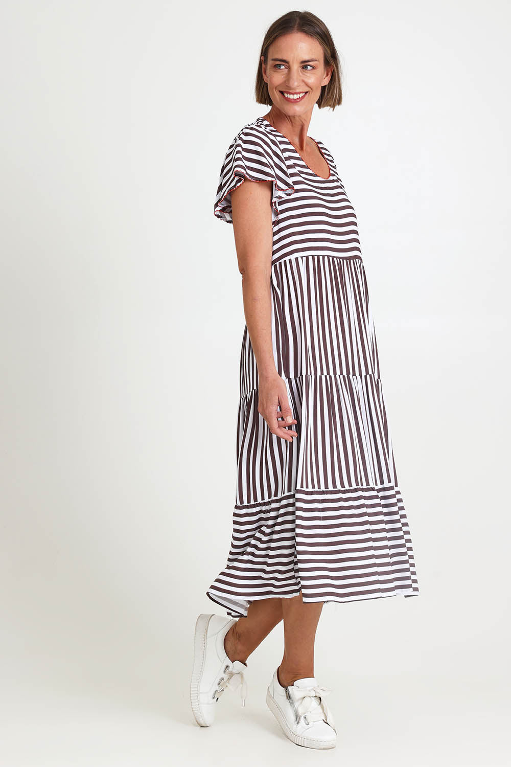 Model Riinar wearing size 10 of the Kalahari Stripe Dress – Coffee in colour Coffee, from the front
