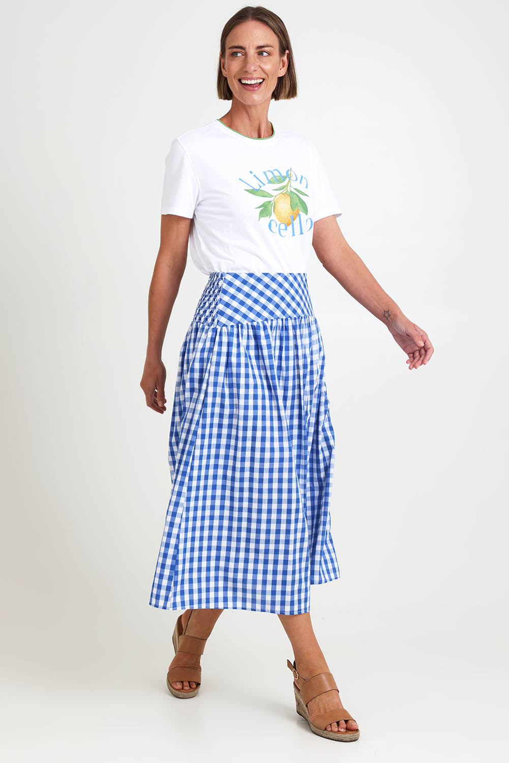 Model Riinar wearing size 10 of the Amalfi Check Skirt – Azure in colour Azure, from the front