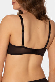 A model wearing the Sheer Minimiser Bra in colour Black (Black), from the back