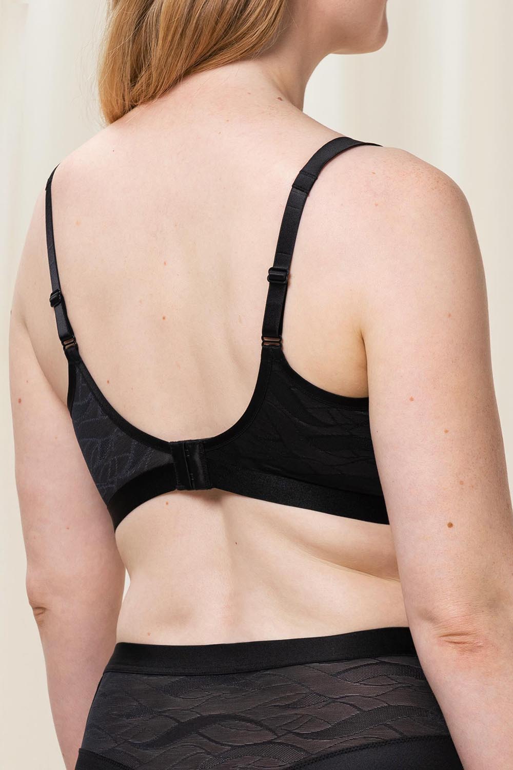 A model wearing the Shape Minimiser Airy Sensation Bra in colour Black (Black), from the back