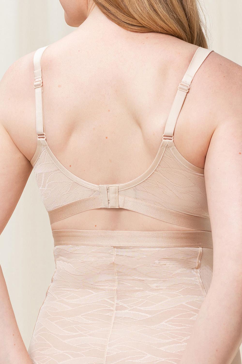 A model wearing the Shape Minimiser Airy Sensation Bra in colour Nudebeige, from the back