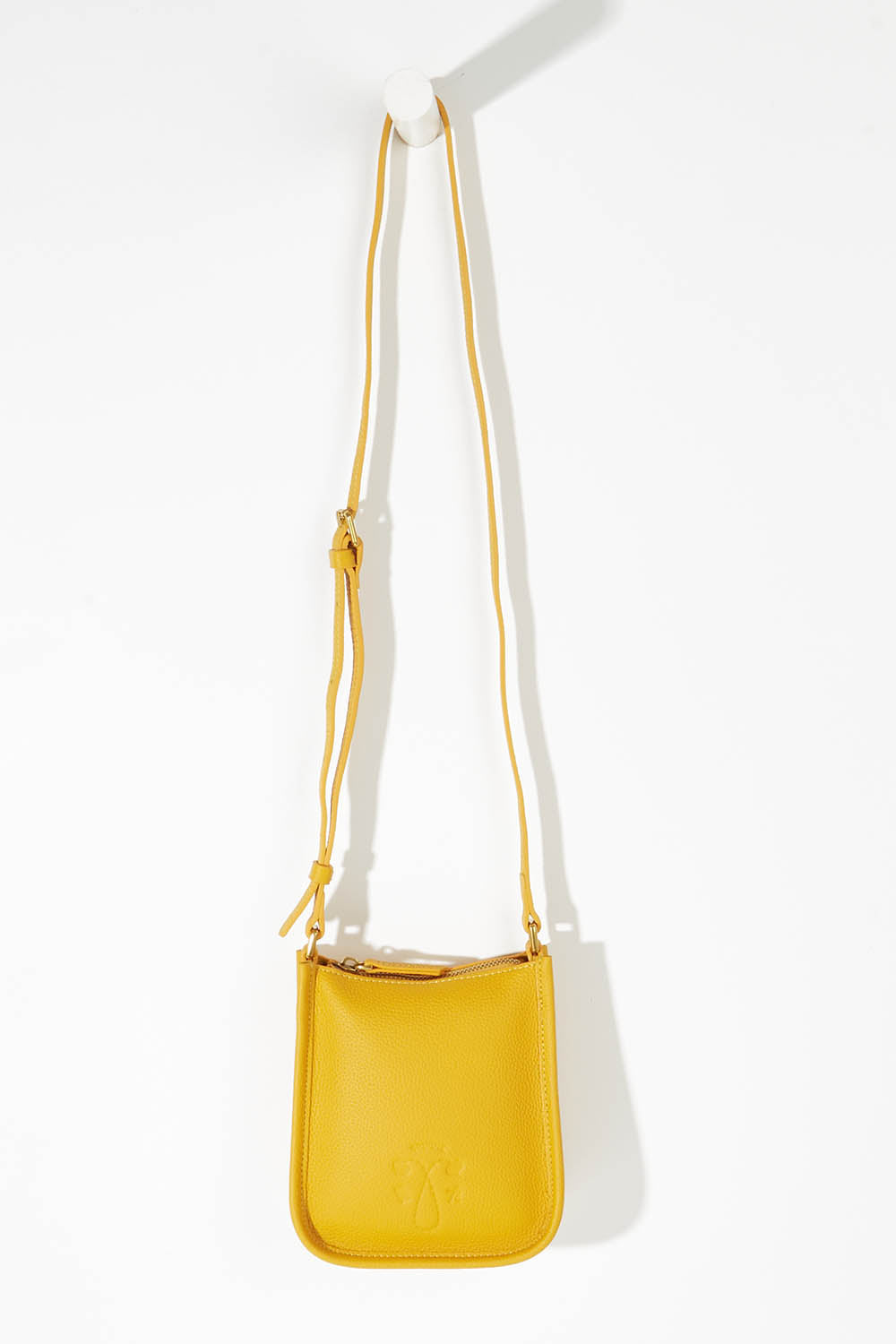A model wearing size OneSize of the Small Leather Crossbody Bag in colour Mustard, from the front, showing the whole outfit