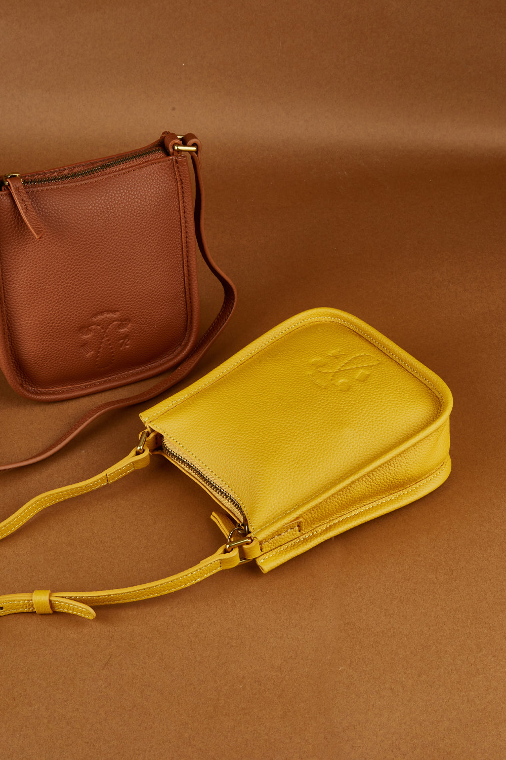A model wearing the Small Leather Crossbody Bag in colour Mustard, from the front, showing the whole outfit