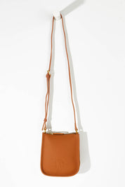 A model wearing size OneSize of the Small Leather Crossbody Bag in colour Tan, from the front, showing the whole outfit