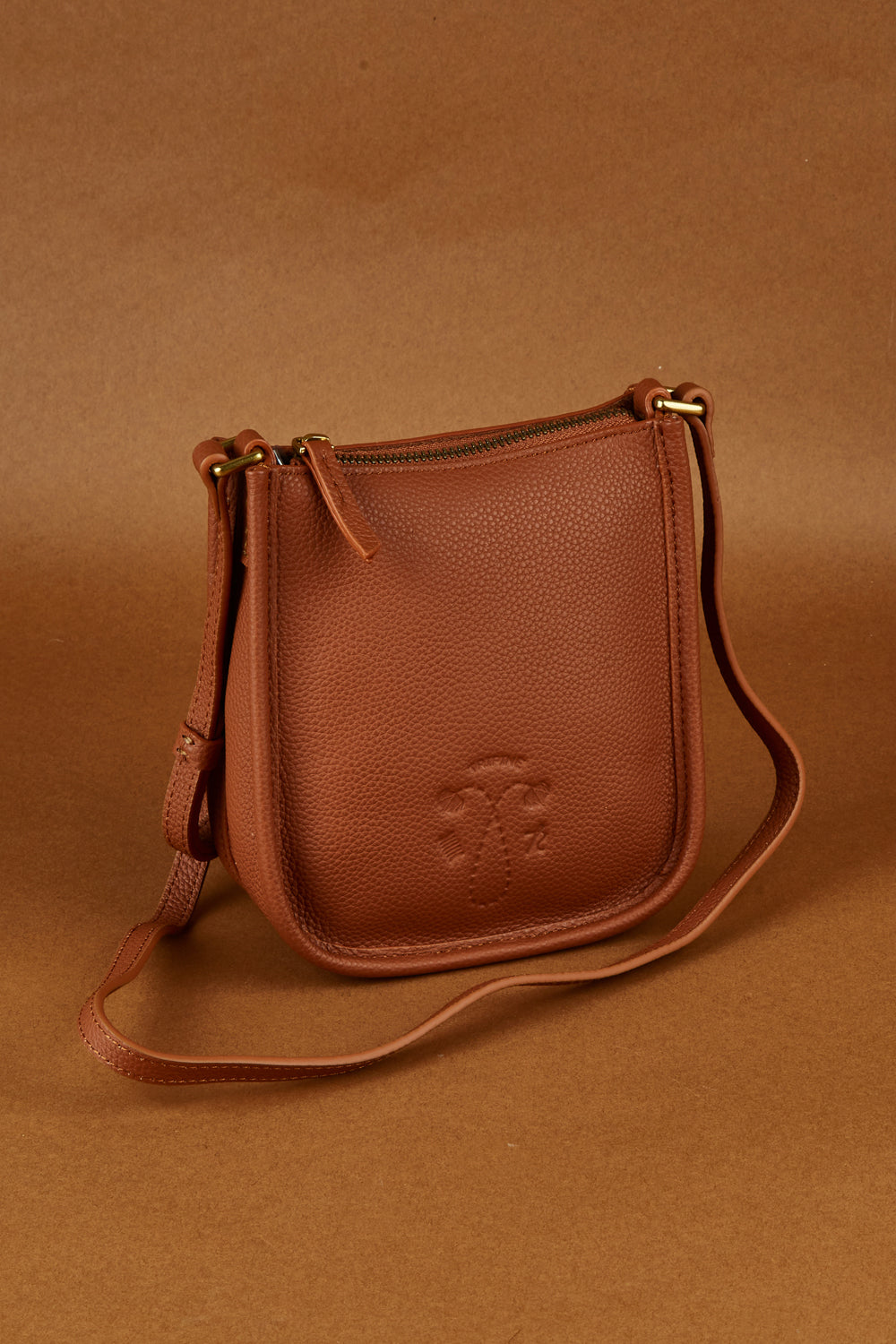 A model wearing the Small Leather Crossbody Bag in colour Tan, from the front, showing the whole outfit