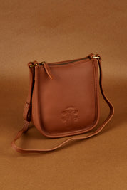 A model wearing the Small Leather Crossbody Bag in colour Tan, from the front, showing the whole outfit