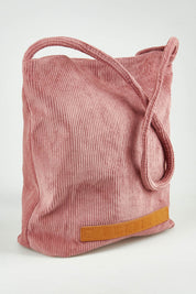 A model wearing the Corduroy Tote Bag in colour Blush (Pink), from the front, showing the whole outfit