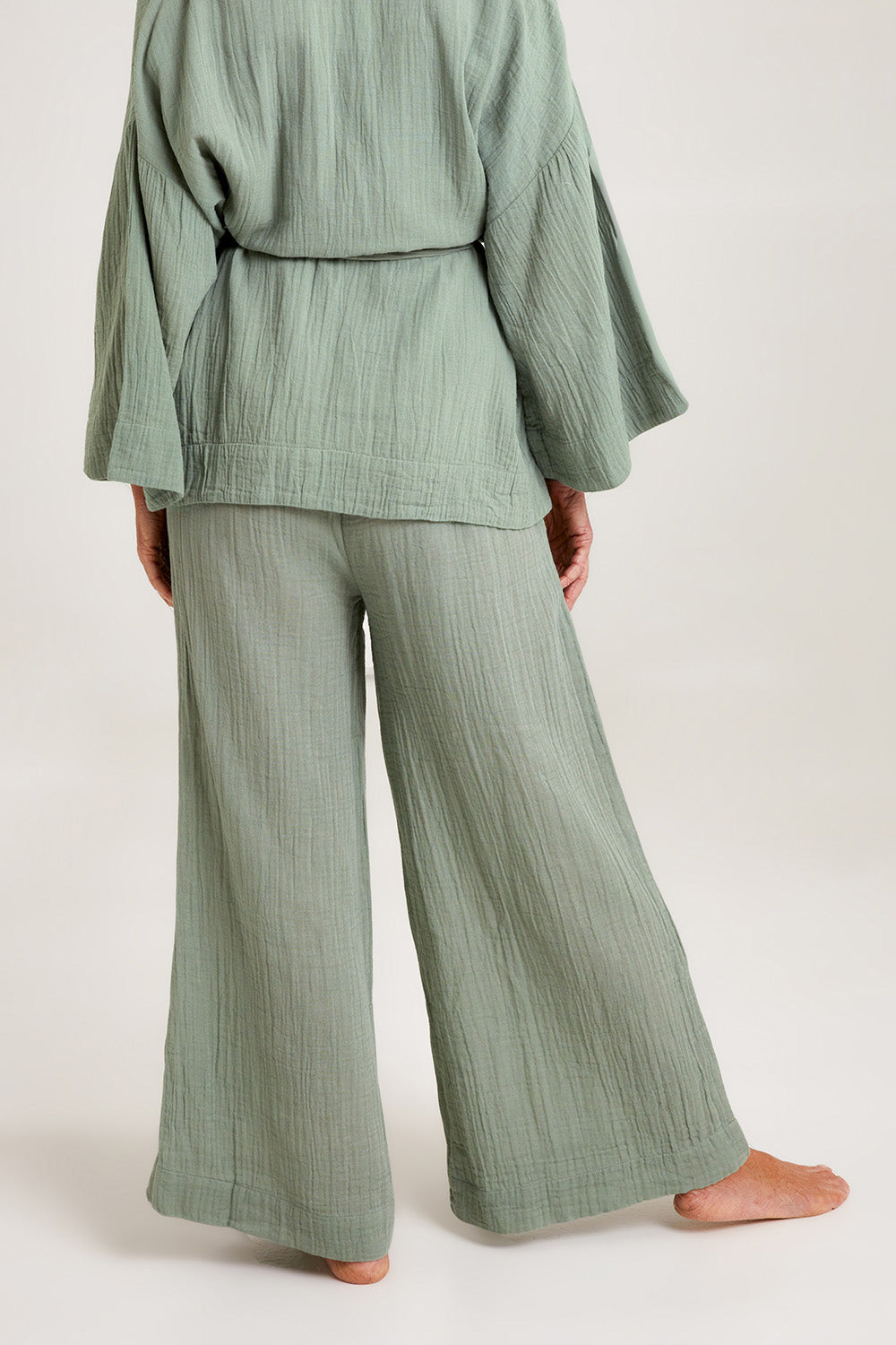 Model Emma wearing the Cotton Wide Leg Lounge Pant in colour Sage (Green), from the back