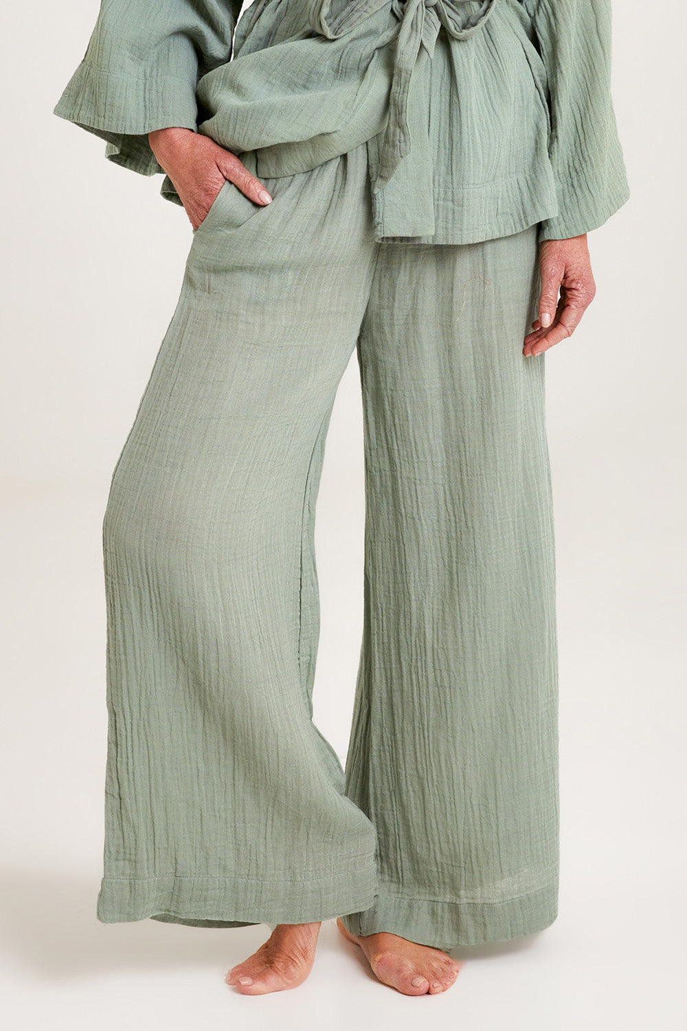 Model Emma wearing the Cotton Wide Leg Lounge Pant in colour Sage (Green), from the front, cropped image