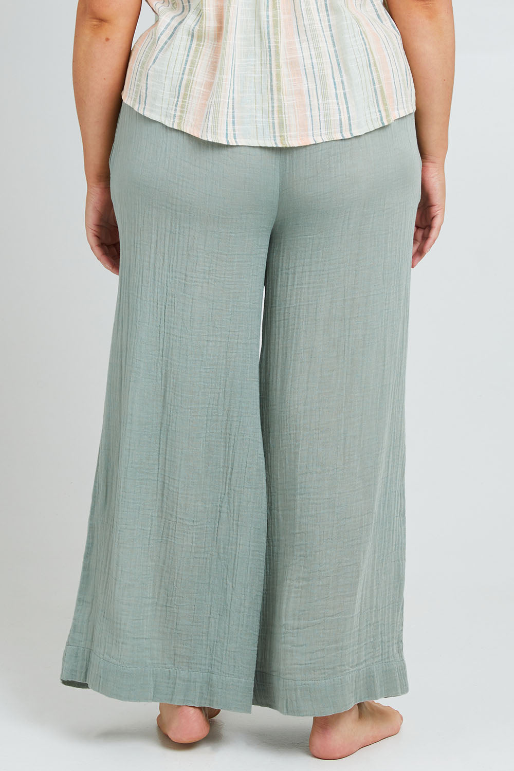 Model Poppy wearing the Cotton Wide Leg Lounge Pant in colour Sage (Green), from the back
