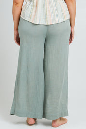 Model Poppy wearing the Cotton Wide Leg Lounge Pant in colour Sage (Green), from the back