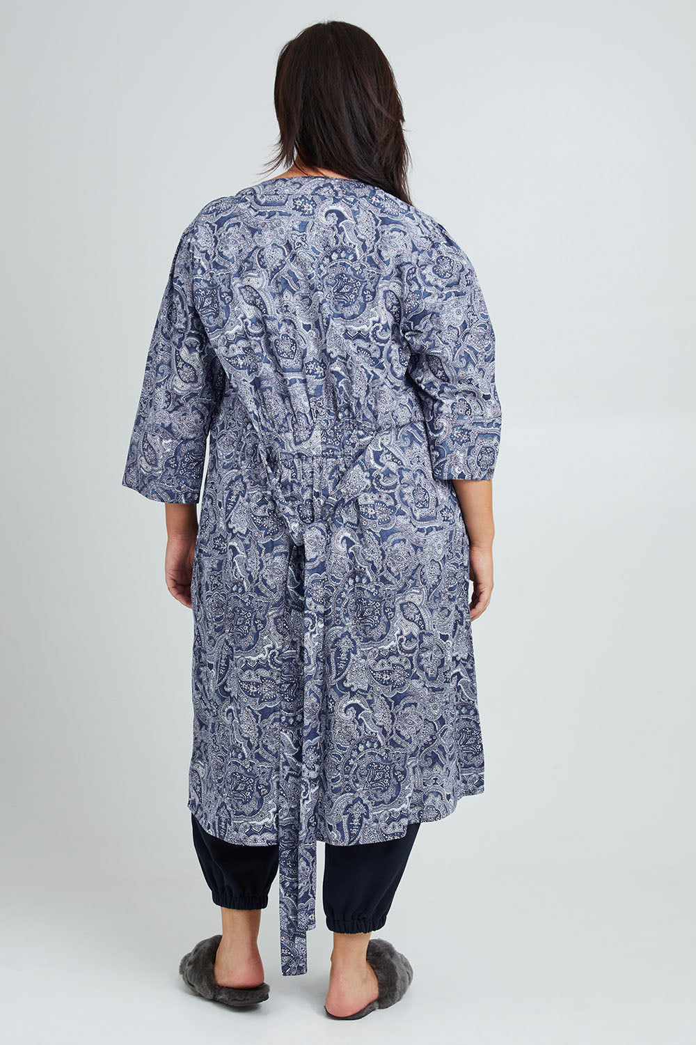 Model Poppy wearing the Summer Cotton Robe With Tie in colour Navypais (Blue), from the back