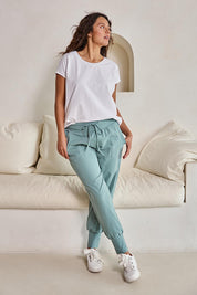 Model Tahneei wearing size 10 of the Cotton Jersey Pull On Jogger – Sage in colour Sage, from the front