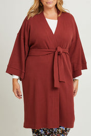 Model Fiona wearing the Cotton Waffle Dressing Robe in colour Rhubarb (Red), from the front, cropped image