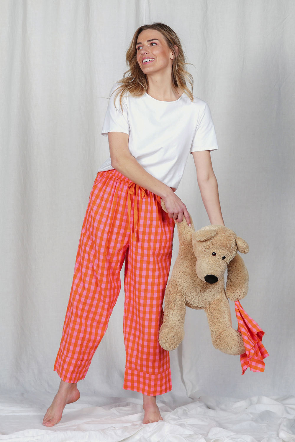 Model Olivia wearing the Cotton Check Pyjama Pants in colour Bright (Pink), from the front, showing the whole outfit