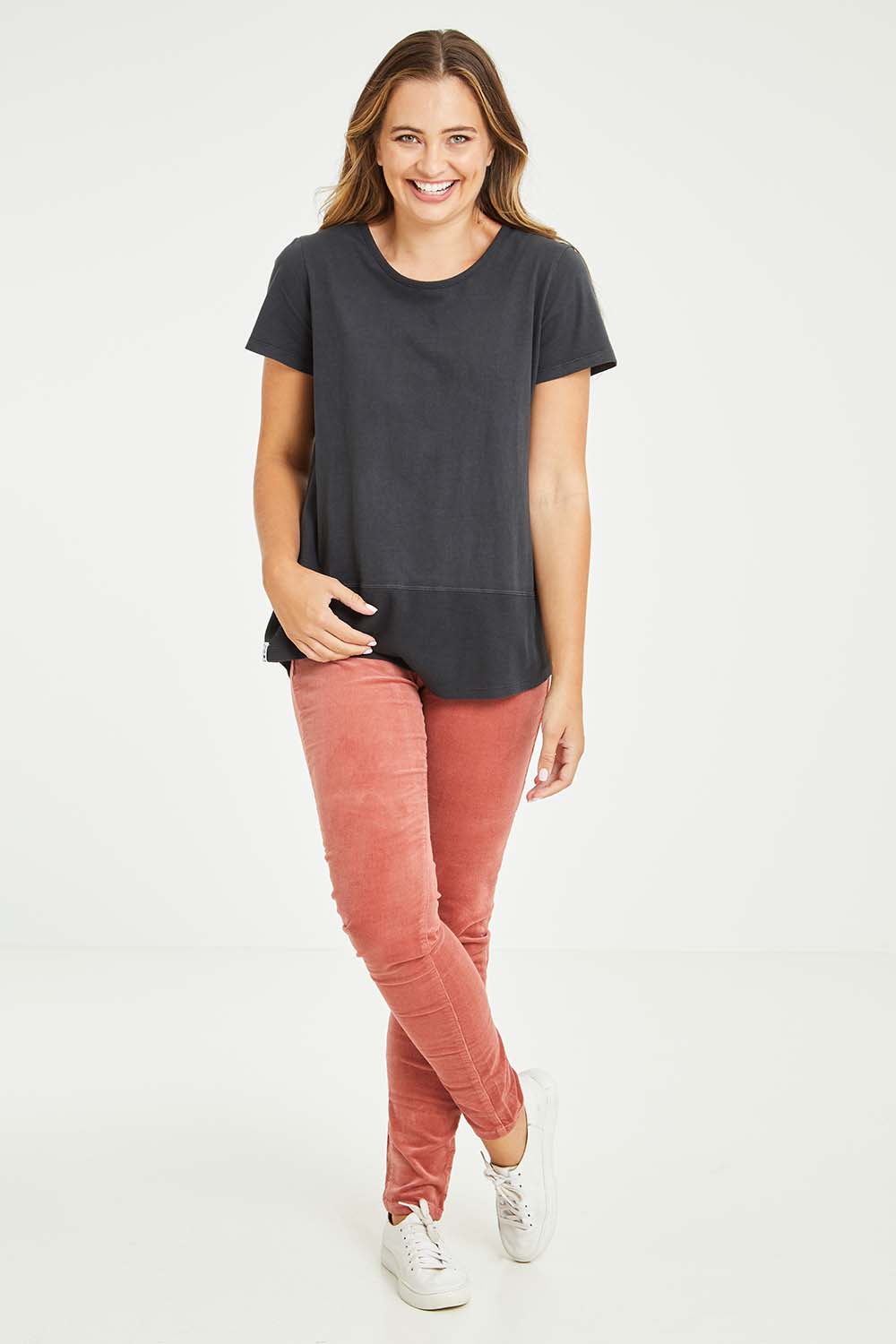 Model Tahlia wearing size 10 of the Skinny Leg Cord Pull On Pant in colour Rose (Pink), from the front, showing the whole outfit