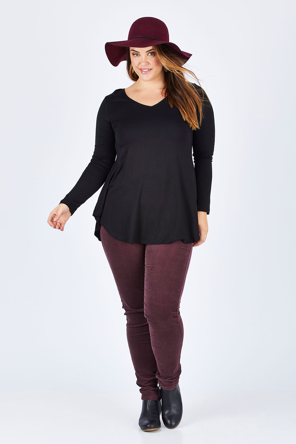Model Sophie wearing size 14 of the Skinny Leg Cord Pull On Pant in colour Vino (Purple), from the front, showing the whole outfit