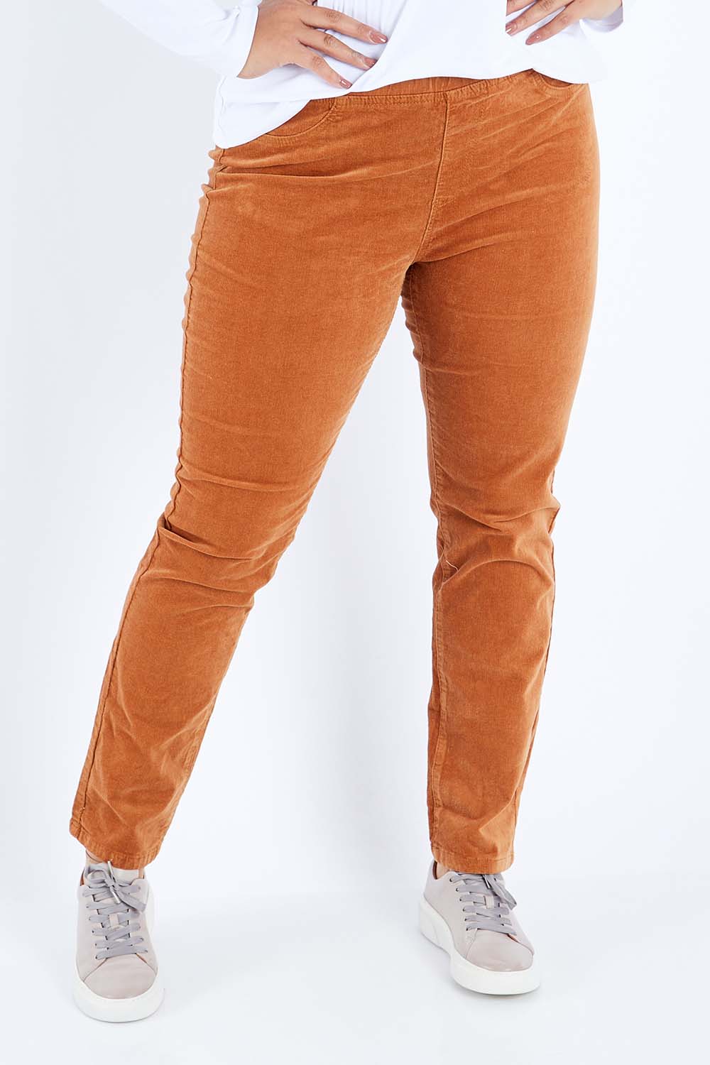 Model Sasha-Lee wearing size 16 of the Pin Cord Slim Pant in colour Copper, from the front, cropped image