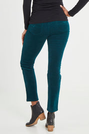 Model Aiyana wearing size 10 of the Pin Cord Slim Pant in colour Peacock (Green), from the back