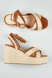 A model wearing size 37 of the Callipo Wedge Heel in colour Tanraffia, from the front, showing the whole outfit
