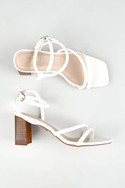 A model wearing size 37 of the Nadia Heel in colour White (White), from the front, showing the whole outfit